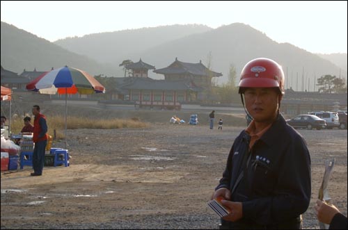 충화면 가화리 드라마 <서동요> 세트장에서 관광객들에게 관광 안내장을 나눠주는 김영완씨 